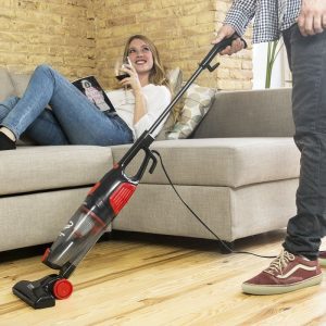 hombre con aspirador escoba con cable