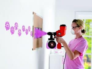 mujer pintando con pistola para pintar