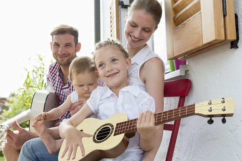 familia cono niña y padre tocando la guitarra