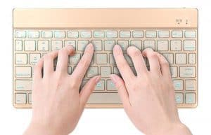 manos tecleando en un mini teclado portatil