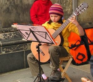 niña seria tocando la guitarra