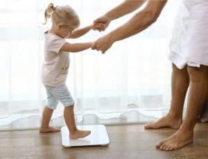 niña subiendo a la bascula de baño