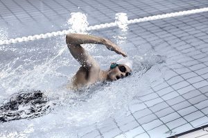 chico haciendo natación profesional con auriculares