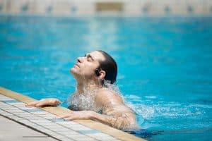 hombre saliendo del agua con auriculares resistentes al agua