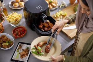 mujer cocinando con freidora sin aceite