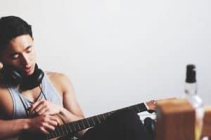 chico con auriculares y guitarra