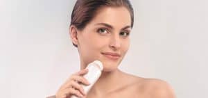 mujer usando cepillo de limpieza facial